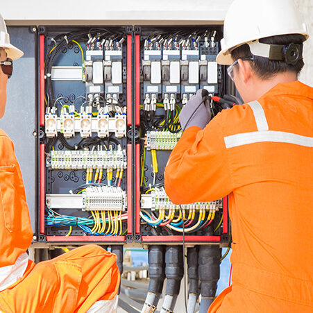 A skills assessor overseeing a worker on an oil & gas platform
