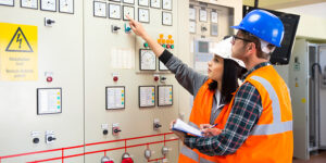 Employees inspecting high voltage electrical equipment at their workplace