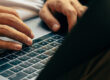 Worker using a laptop to conduct a remote competence assessment