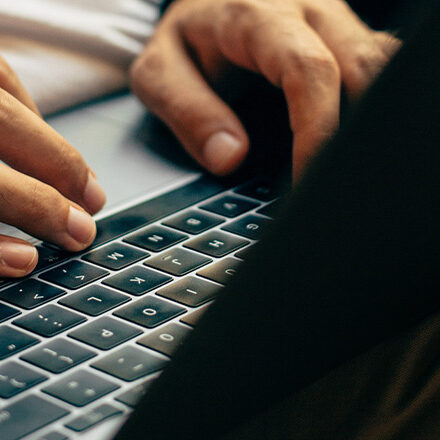 Worker using a laptop to conduct a remote competence assessment