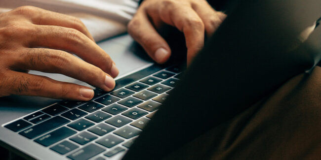 Worker using a laptop to conduct a remote competence assessment